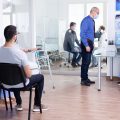 Elderly man at hospital reception wearing face mask and taking with nurse while waiting for coronavirus examination. Social distancing, medic, covid-19, man, worried, protection, corona,